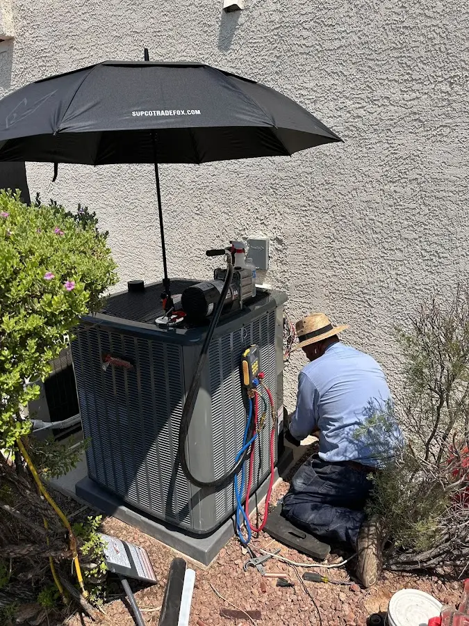 HVAC technician performing outdoor AC maintenance in Boaz