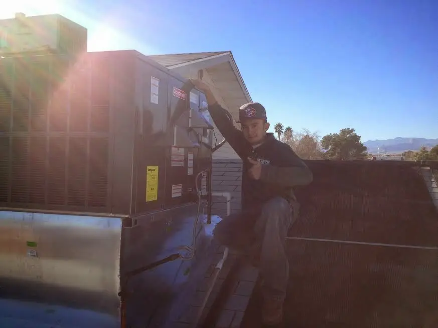 HVAC technician performing Heat Pump Repair on a rooftop unit in Boaz